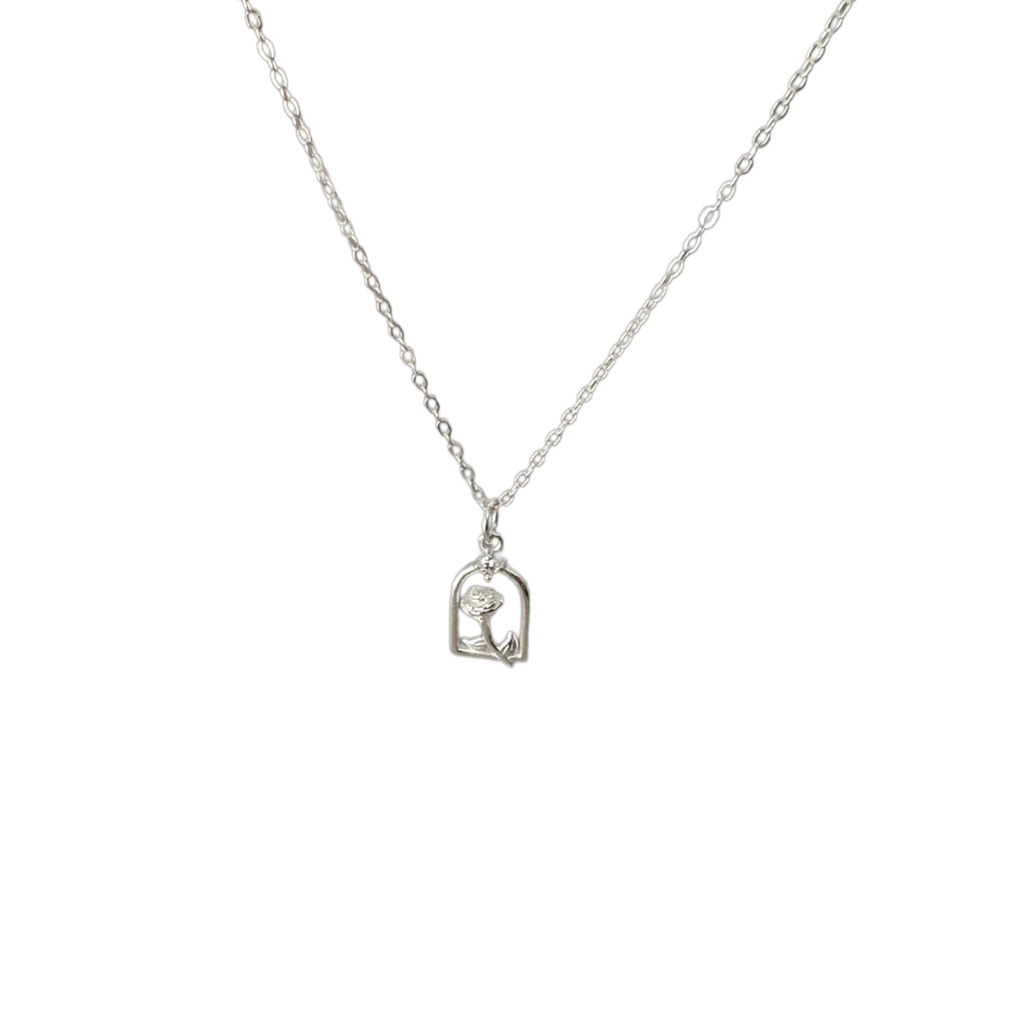 Silver necklace with a rose-shaped pendant, outlined in a archway and featuring small white stones.