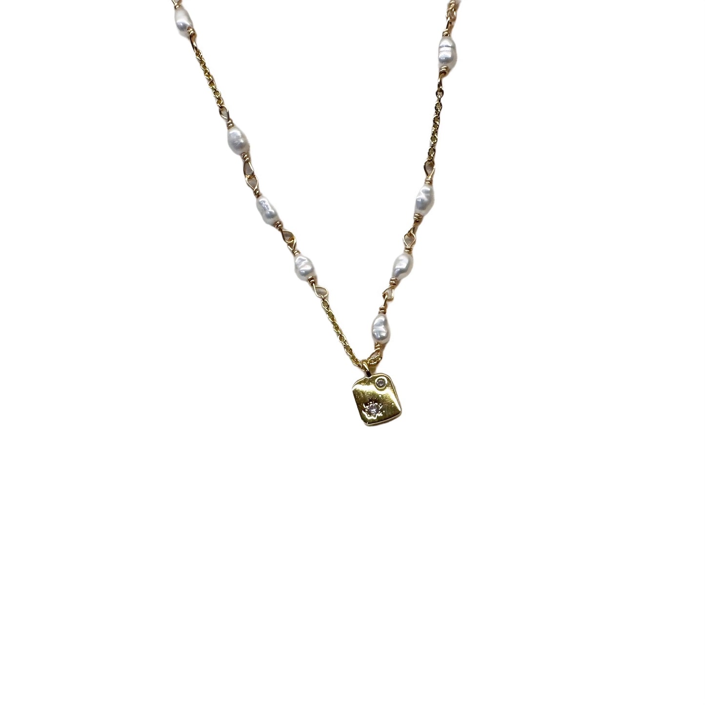 Gold necklace featuring a pearl pendant and a small heart charm, elegantly designed for a sophisticated look.