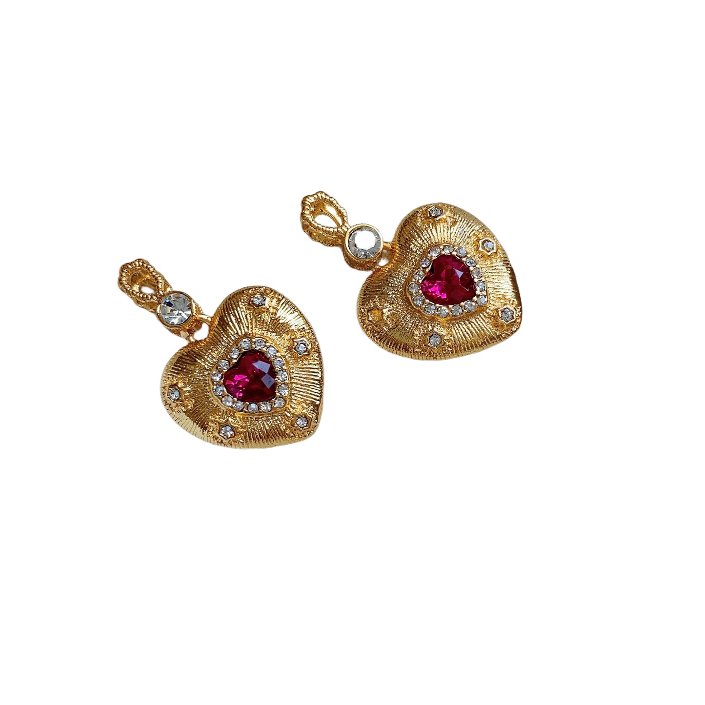Gold heart-shaped earrings with ruby-red centers and small white crystals.