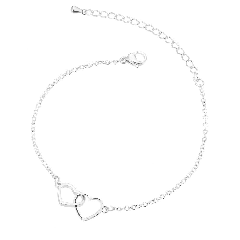 A delicate silver bracelet showcasing two intertwined hearts, embodying love and togetherness.