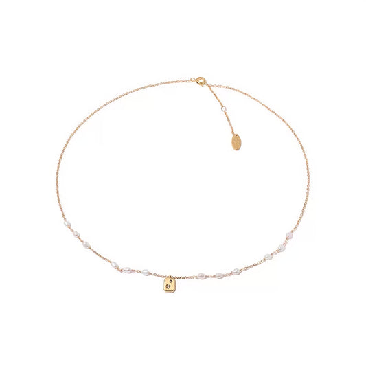 Gold necklace featuring a pearl and a gold charm, elegantly designed for a sophisticated look.