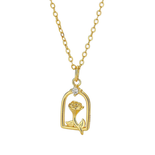 Gold necklace with a rose-shaped pendant, outlined in a archway and featuring small white stones.