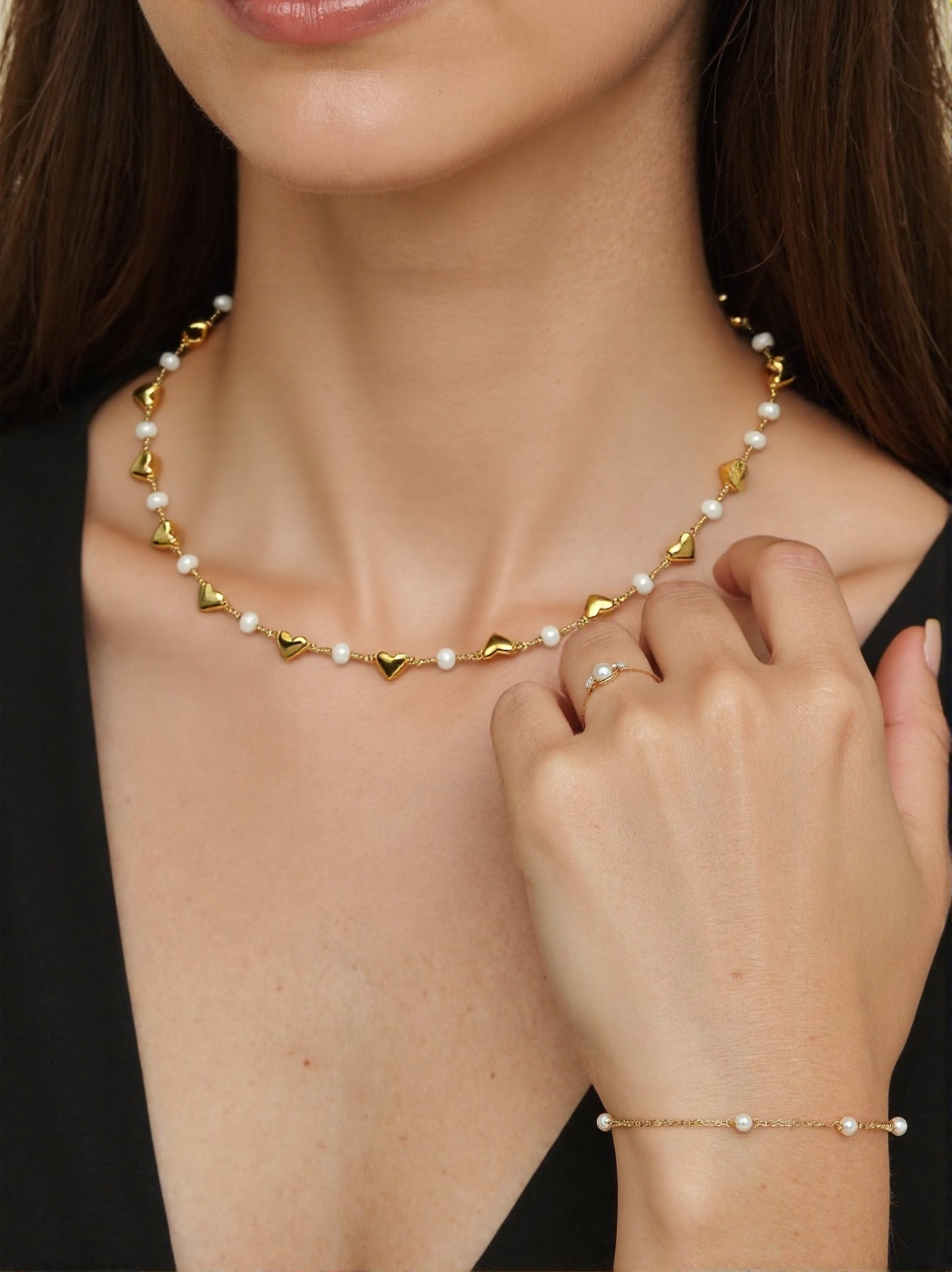 Gold chain adorned with small heart-shaped charms, elegantly showcasing a delicate and romantic design.