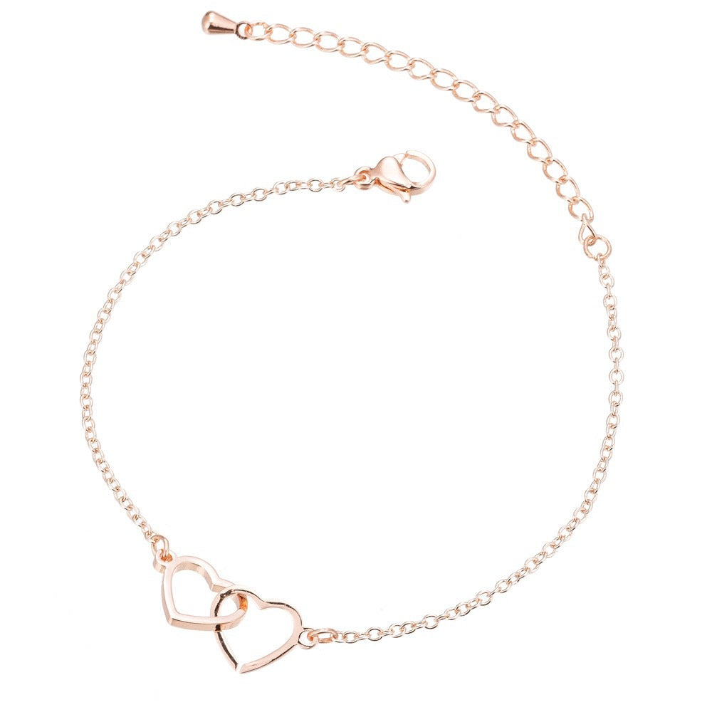 A delicate rose gold bracelet showcasing two intertwined hearts, embodying love and togetherness.