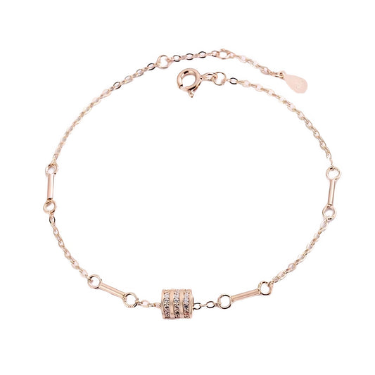 Rose gold bracelet with a diamond-studded cylinder charm and connecting bar links.