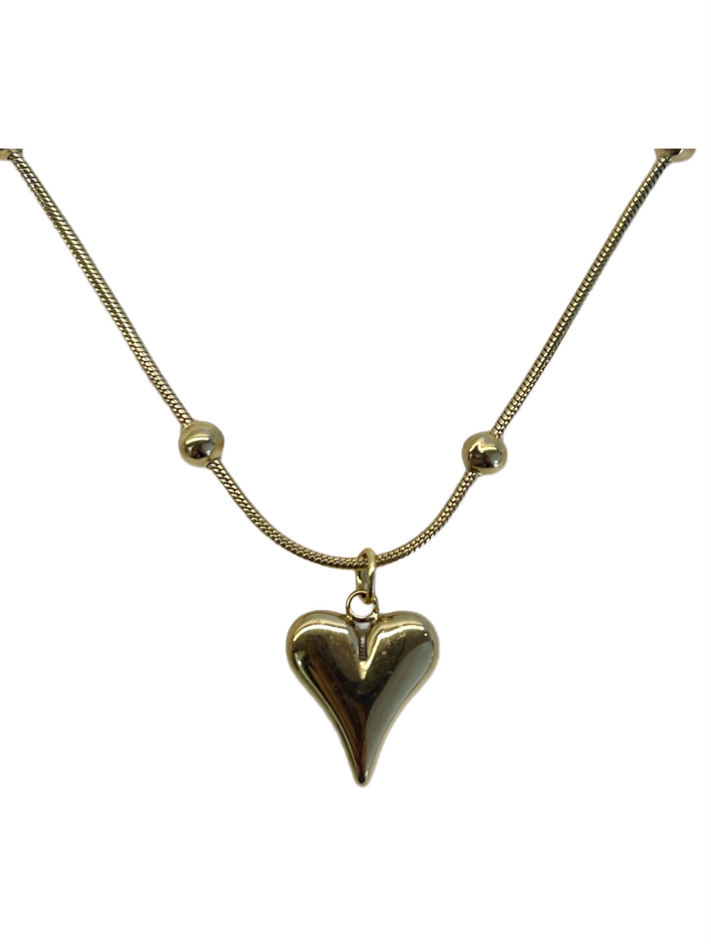 Gold necklace with a heart-shaped pendant and small ball accents.