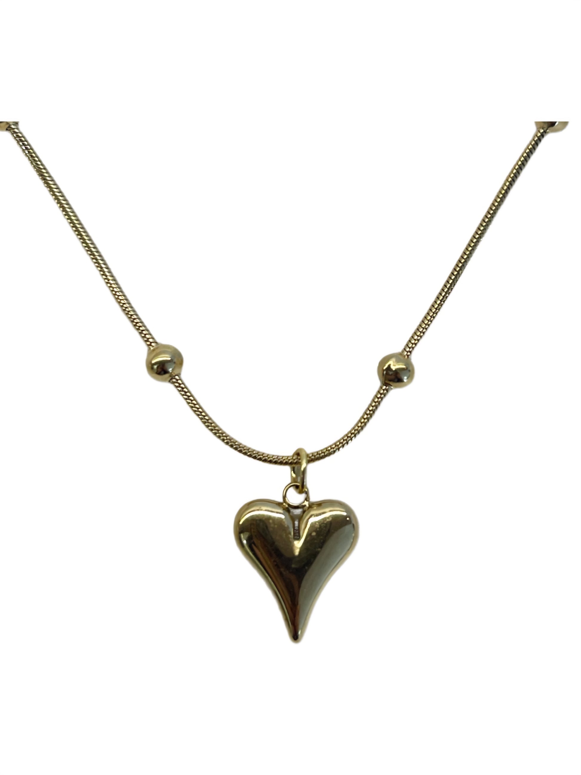 Gold necklace with a heart-shaped pendant and small ball accents.